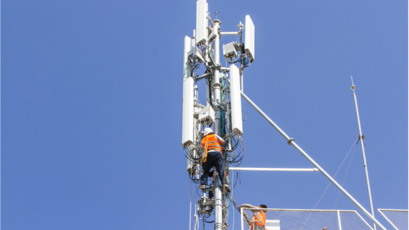 Technician working on communications tower - 5G